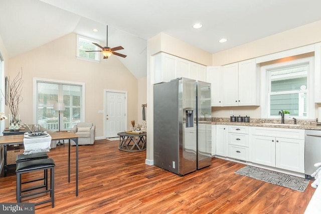 kitchen with stainless steel appliances, white cabinetry, hardwood / wood-style flooring, and sink