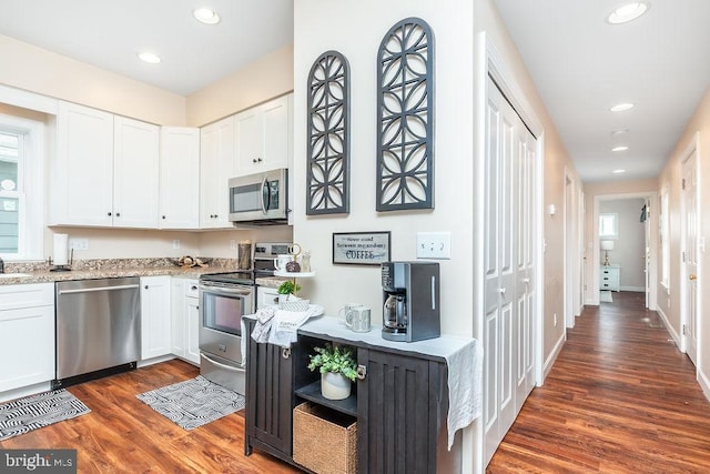 kitchen featuring white cabinetry, light stone countertops, stainless steel appliances, and dark hardwood / wood-style floors