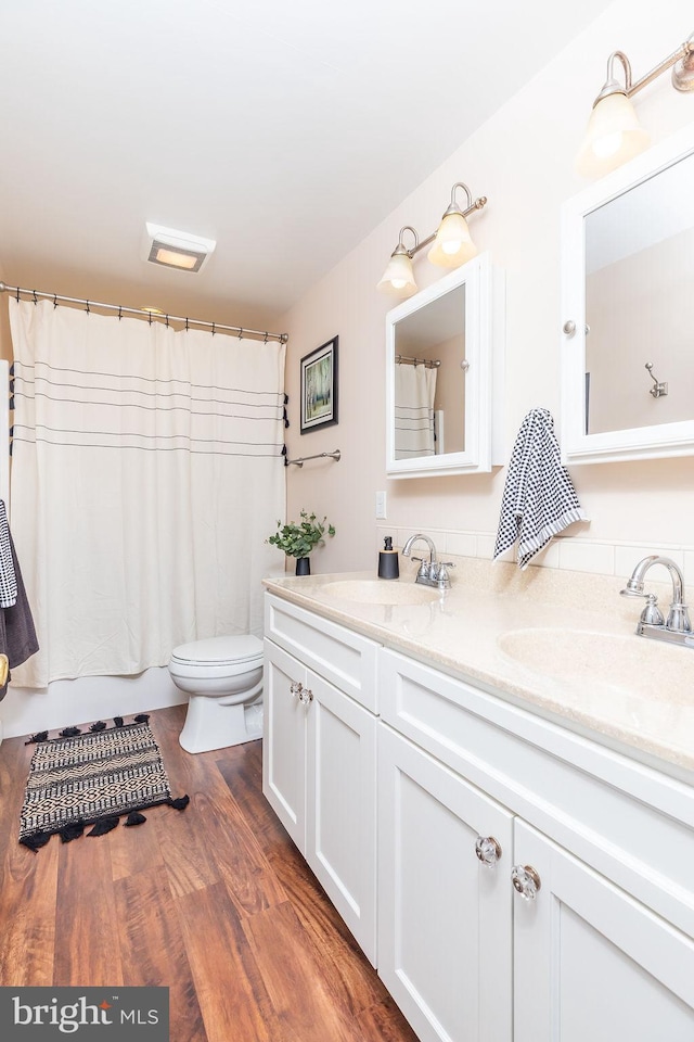 bathroom featuring vanity, hardwood / wood-style floors, and toilet