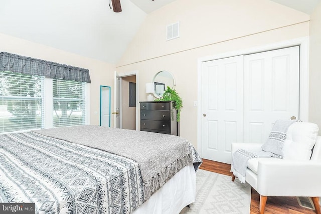 bedroom with lofted ceiling, hardwood / wood-style flooring, a closet, and ceiling fan