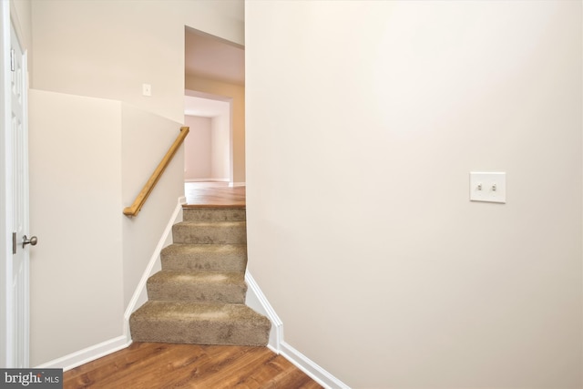 stairway featuring wood finished floors and baseboards