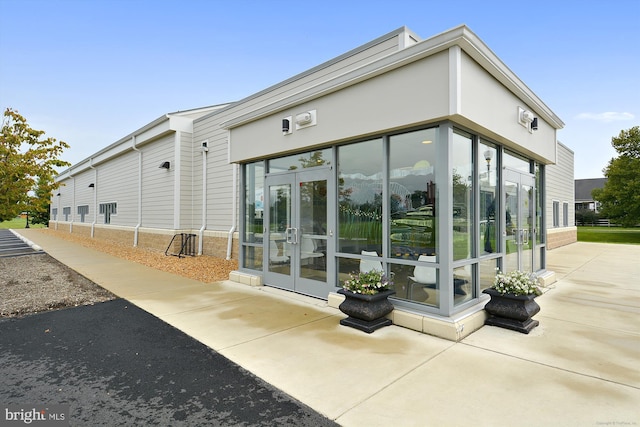 view of side of home with french doors and a sunroom