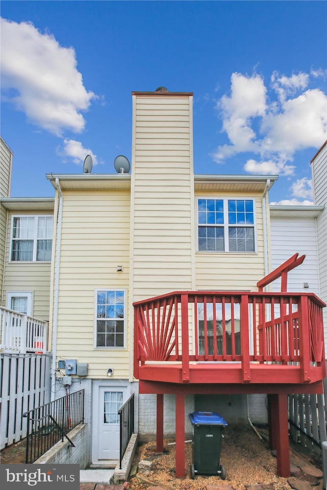 rear view of house featuring fence and a chimney