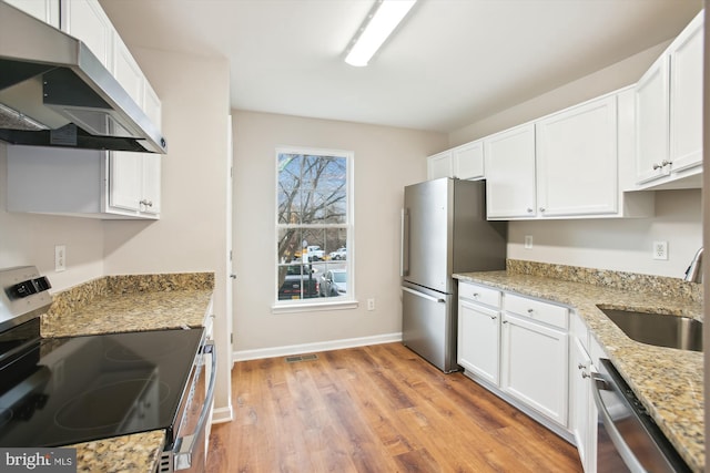 kitchen featuring visible vents, ventilation hood, appliances with stainless steel finishes, and white cabinets