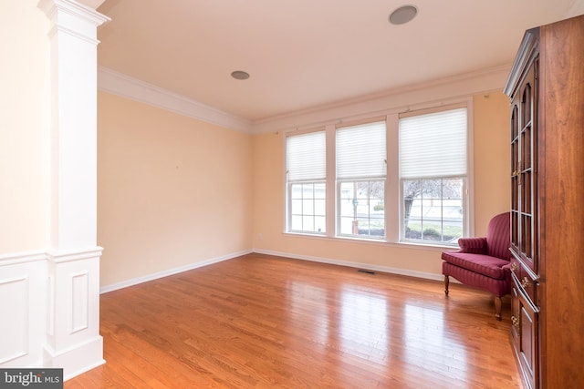 sitting room with ornamental molding, light hardwood / wood-style flooring, and ornate columns