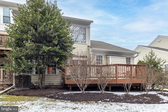 snow covered rear of property featuring a deck and cooling unit