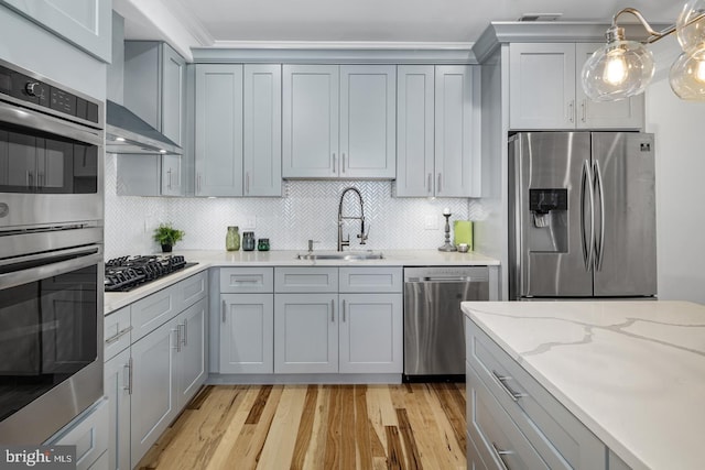 kitchen with tasteful backsplash, gray cabinets, sink, light stone countertops, and stainless steel appliances