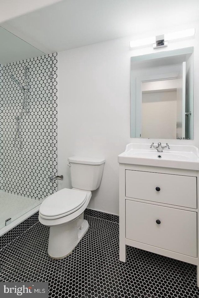 bathroom featuring a shower, toilet, and vanity