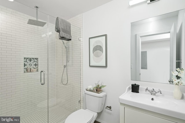 bathroom featuring toilet, vanity, and an enclosed shower