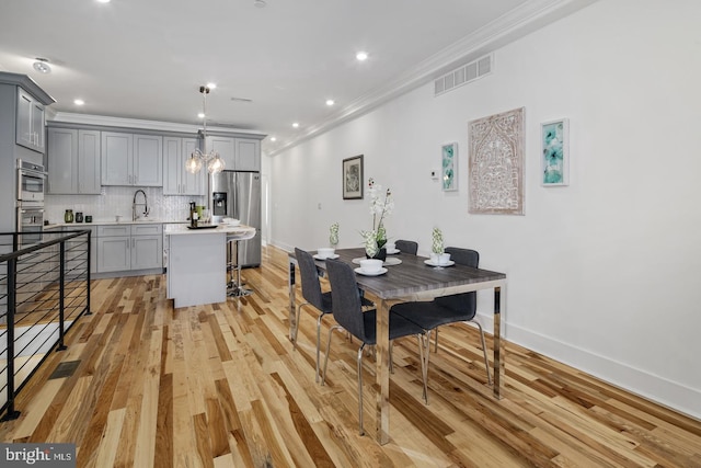 kitchen featuring backsplash, a kitchen island, sink, gray cabinetry, and stainless steel appliances