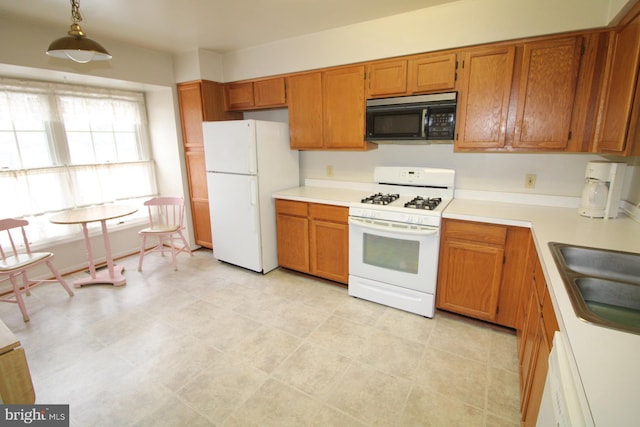 kitchen with pendant lighting, sink, and white appliances