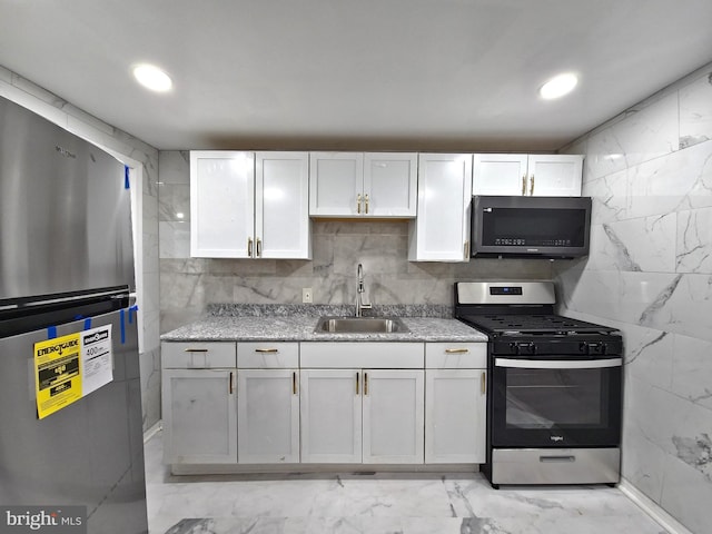 kitchen featuring sink, stainless steel appliances, and white cabinetry