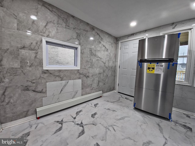 interior space featuring baseboard heating and stainless steel refrigerator