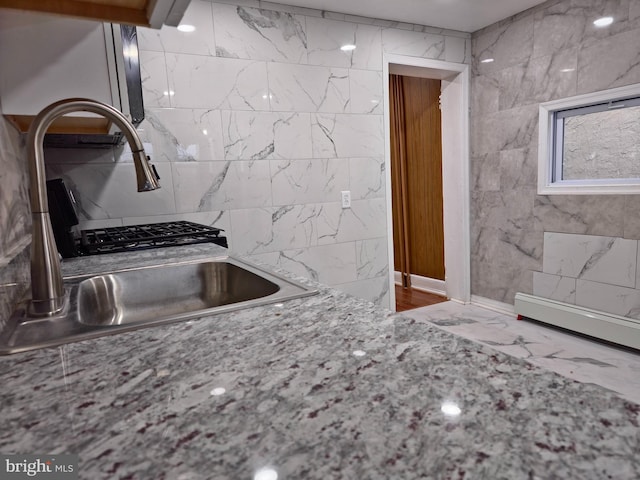 kitchen featuring tile walls and sink