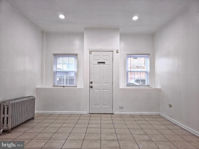 tiled foyer entrance featuring plenty of natural light and radiator heating unit