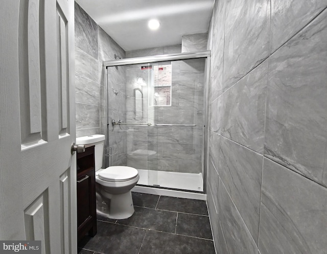 bathroom with walk in shower, vanity, tile walls, and toilet