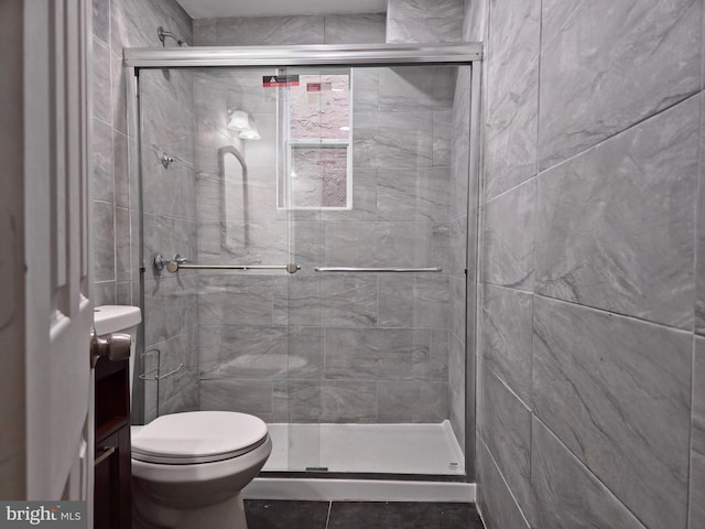 bathroom featuring toilet and an enclosed shower