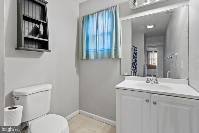 bathroom with toilet, vanity, and tile patterned floors