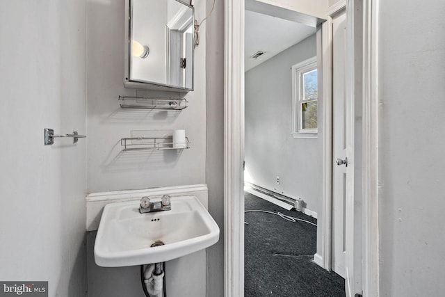 bathroom featuring sink and a baseboard heating unit