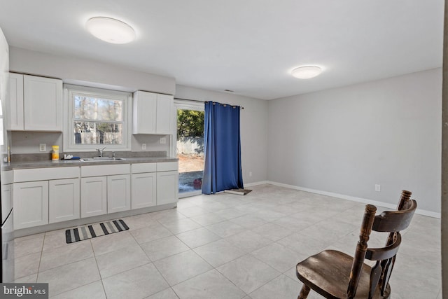 kitchen featuring white cabinets, sink, and light tile patterned floors