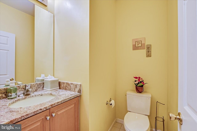 bathroom with toilet, vanity, and tile patterned flooring