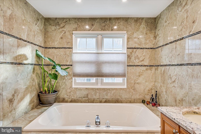 bathroom featuring a tub, tile walls, and vanity