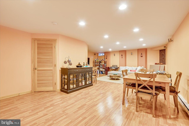 dining space featuring light wood-type flooring and a baseboard heating unit