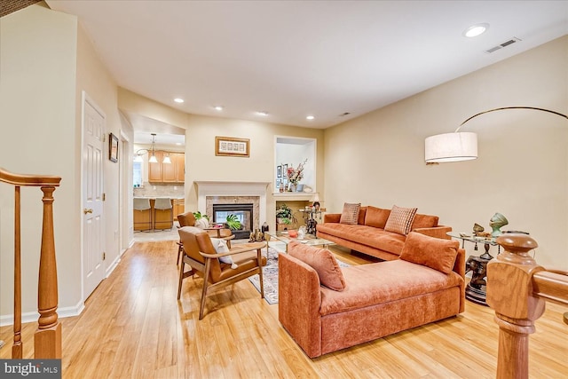 living room with a premium fireplace and light hardwood / wood-style flooring