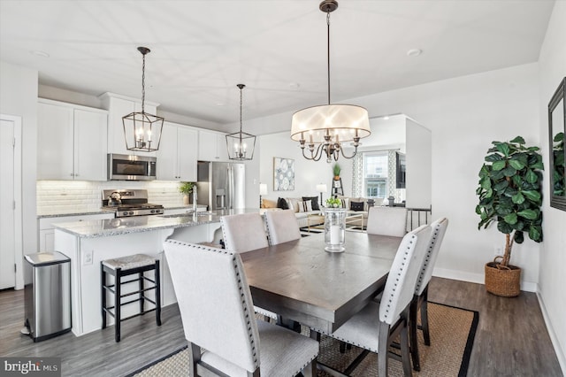 dining area featuring dark hardwood / wood-style floors and a chandelier