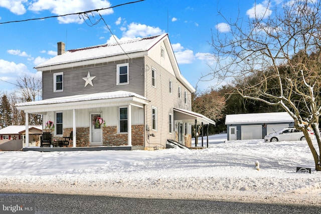 view of front facade featuring covered porch, an outdoor structure, and a garage