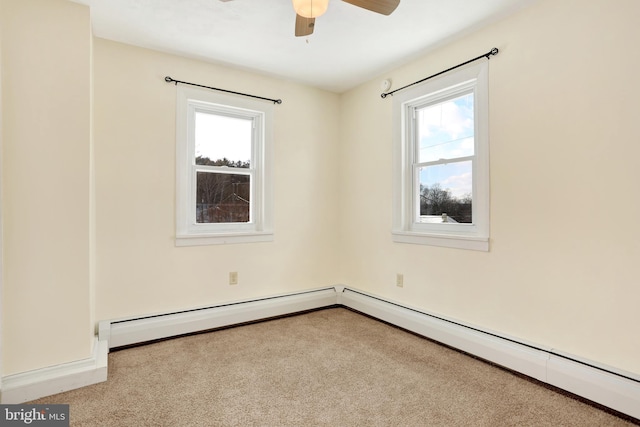 carpeted spare room featuring ceiling fan, a wealth of natural light, and baseboard heating