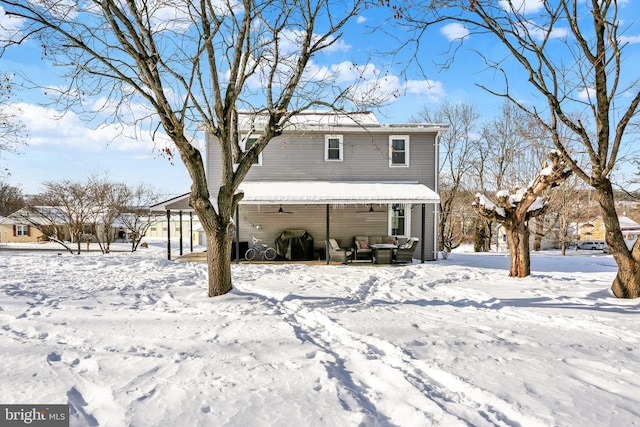 view of snow covered rear of property