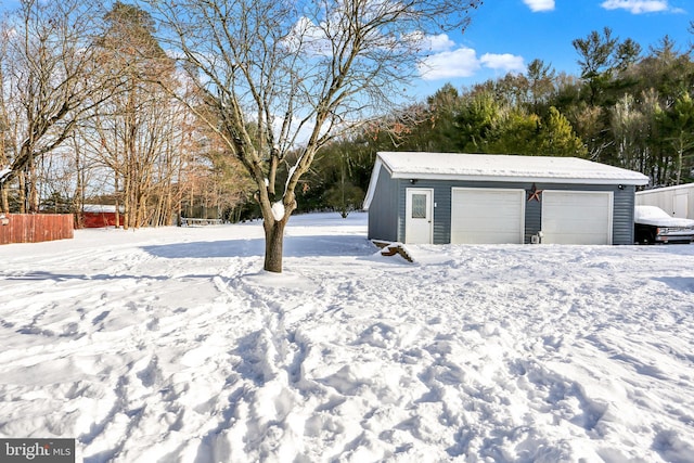 snowy yard with an outdoor structure and a garage