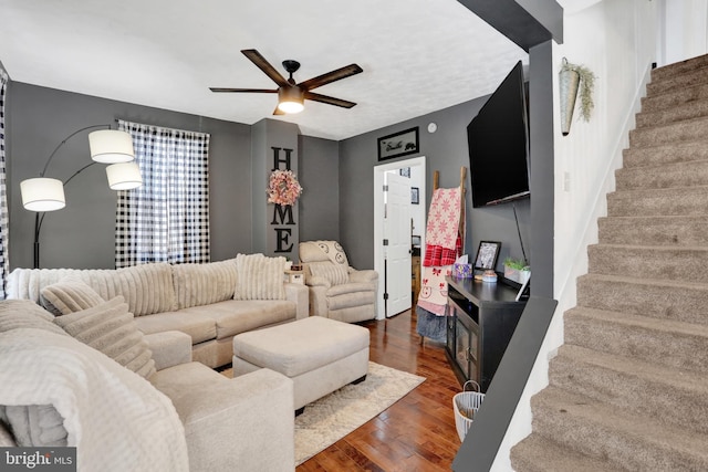 living room with ceiling fan and dark wood-type flooring