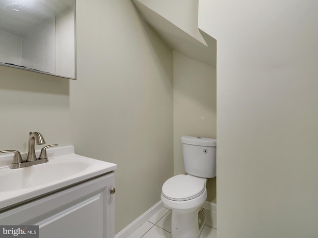 bathroom with toilet, vanity, and tile patterned floors