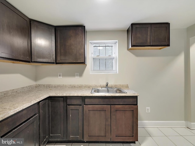 kitchen featuring light tile patterned flooring, sink, and dark brown cabinetry