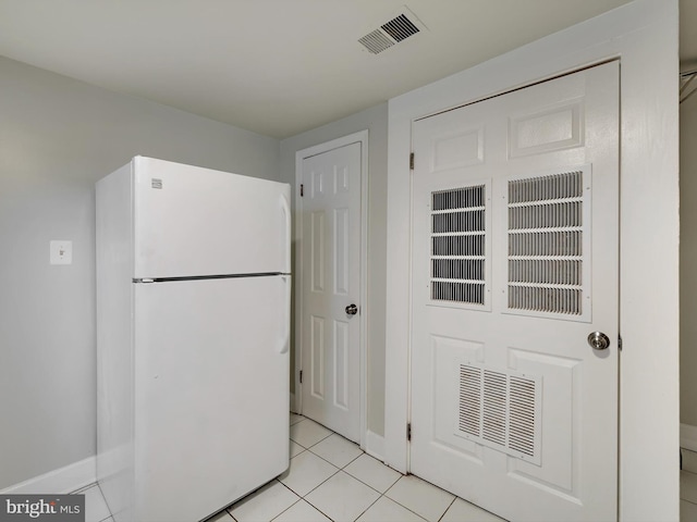 kitchen with light tile patterned floors and white fridge