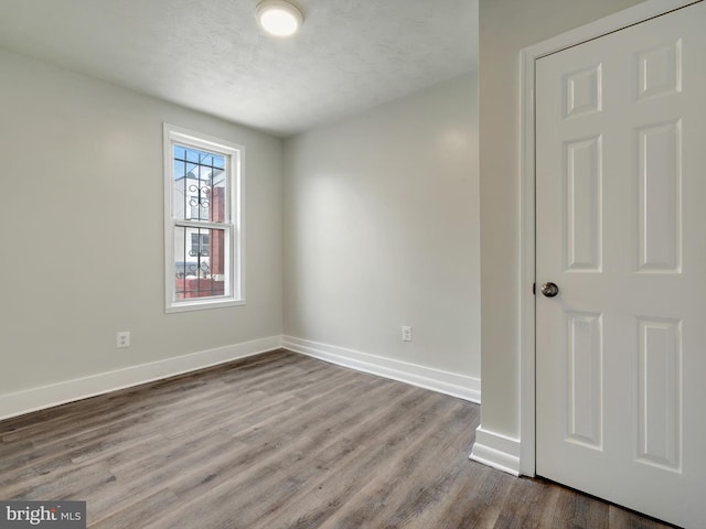 empty room with wood-type flooring and a textured ceiling