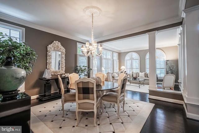 dining space with hardwood / wood-style flooring, ornamental molding, plenty of natural light, and decorative columns