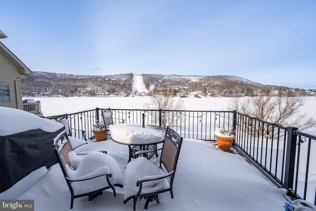 snow covered back of property featuring a grill