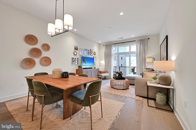 dining room with an inviting chandelier and light hardwood / wood-style flooring