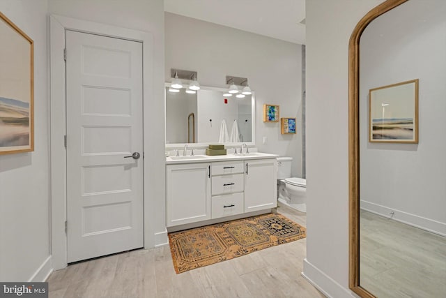 bathroom with toilet, hardwood / wood-style flooring, and vanity