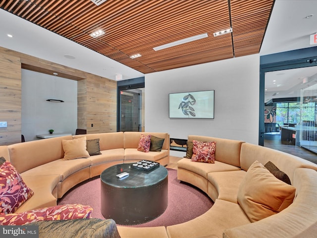 living room featuring wood ceiling and wood walls