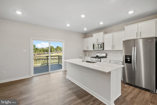 kitchen with white cabinetry, stainless steel appliances, a center island with sink, and sink