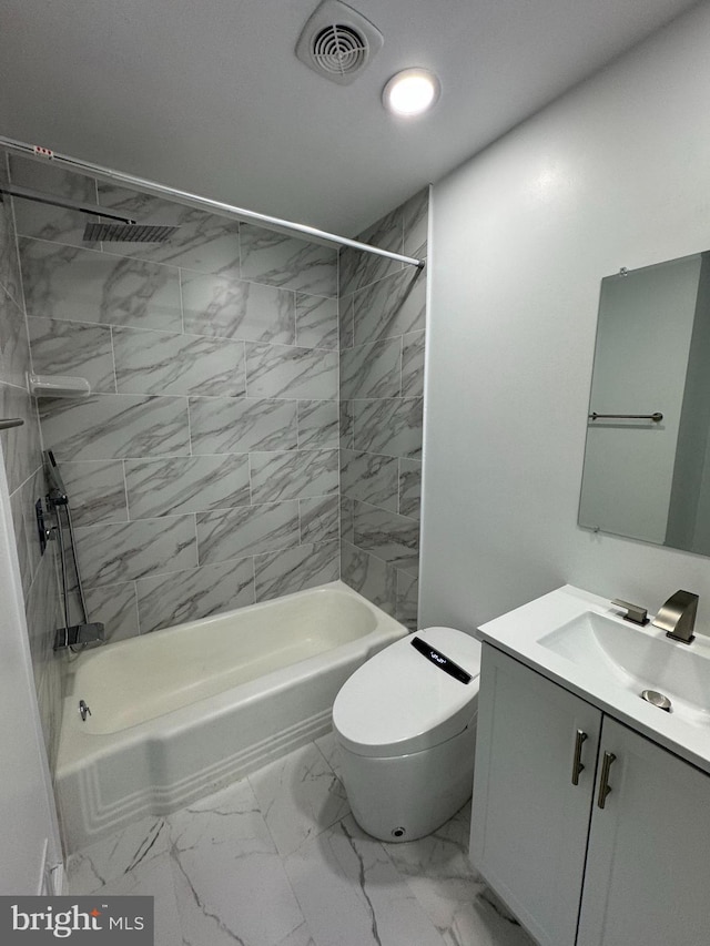 full bathroom with tiled shower / bath, vanity, and toilet