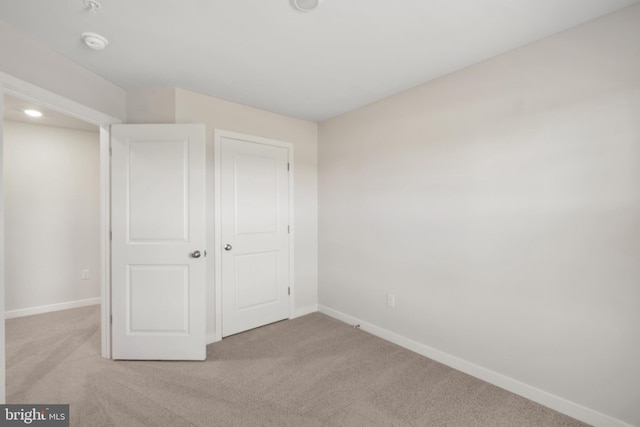 unfurnished bedroom with light carpet and a closet