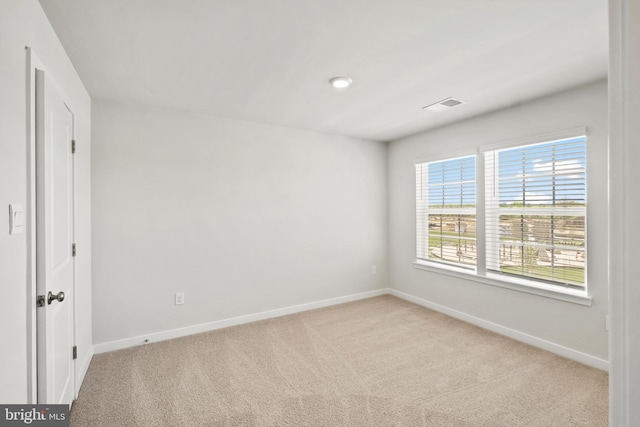 spare room featuring light colored carpet