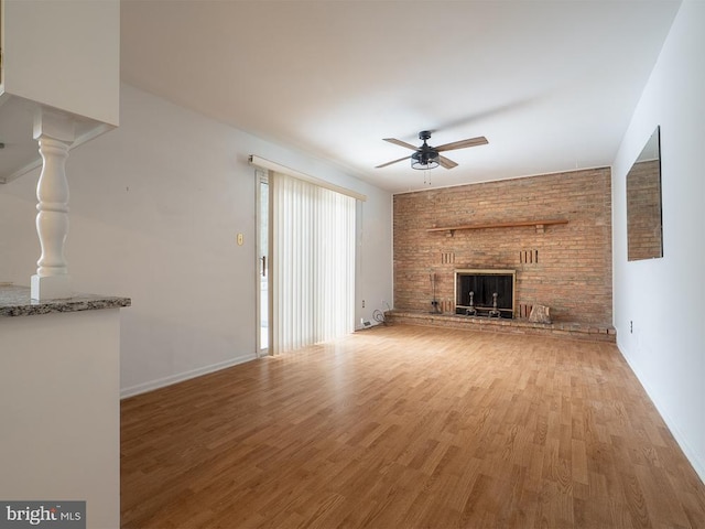 unfurnished living room featuring ceiling fan, a fireplace, and wood-type flooring