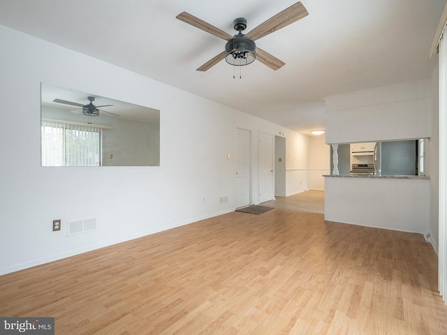 unfurnished living room featuring ceiling fan and light hardwood / wood-style floors