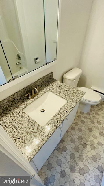 bathroom with toilet, baseboard heating, and vanity